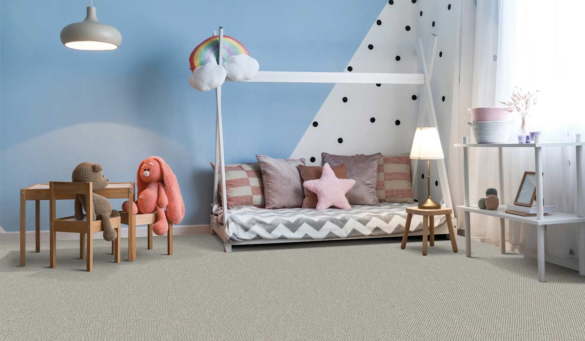 gray carpet in a kids room with blue and polka dotted accent wall