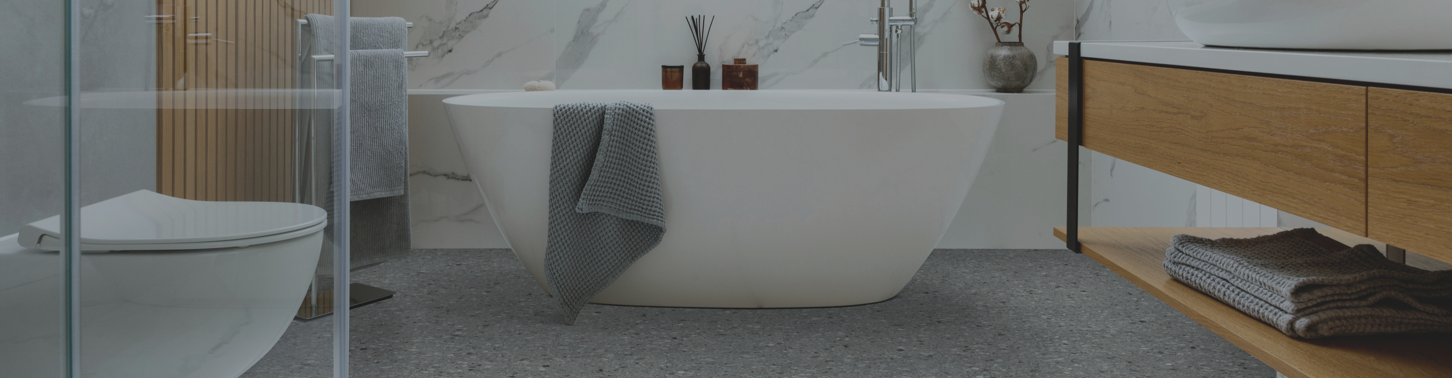 gray flooring in a bathroom with a freestanding tub and floating vanity